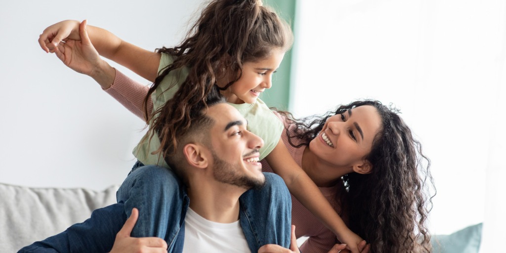 Cheerful Middle Eastern family of three having fun together at home